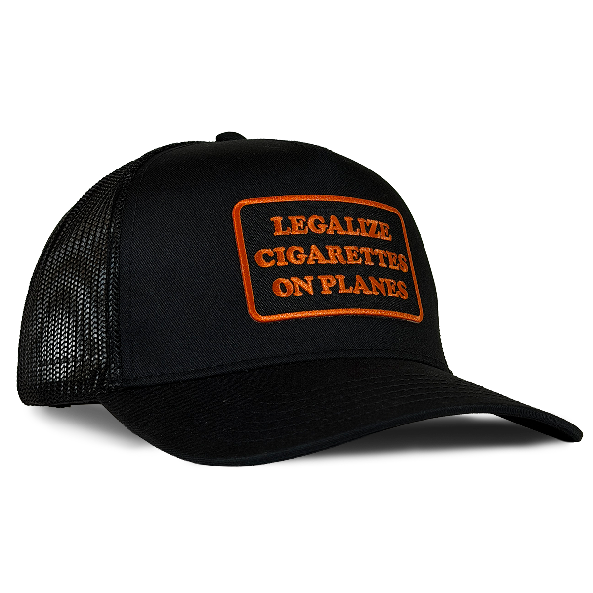A black trucker-style baseball cap with a curved brim and black mesh back panels, featuring an orange embroidered patch on the front with the text 'LEGALIZE CIGARETTES ON PLANES'. Hat by Crying in the Club Shirts