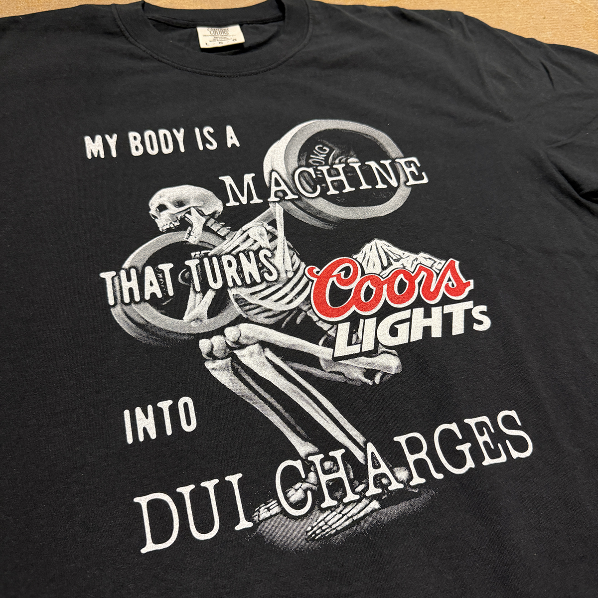 a black t-shirt with a design of a skeleton squatting labelled my body is a machine that turns beer into dui charges, humorous prank shirt cryingintheclub 69